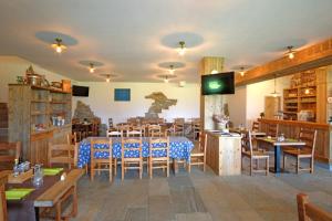 un restaurante con mesas y sillas de madera y TV en Adda Vegia, en Buglio in Monte