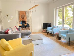 Casa dos Limões في بومبارال: غرفة معيشة مع أريكة وكراسي وتلفزيون