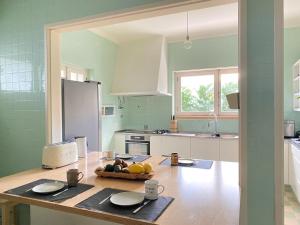 uma cozinha com uma mesa com uma taça de fruta em Casa dos Limões em Bombarral