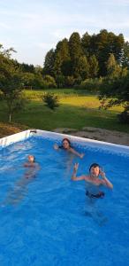 スワエトホルスクにあるFamily Hotel Shaletの三人の若者がスイミングプールで泳ぐ