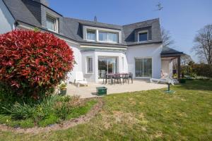 a house with a patio with a table and chairs at A proximité du golfe du Morbihan in Plescop