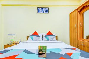 a bedroom with a bed with a colorful comforter at FabExpress Ragu Residency in Coimbatore