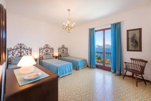 een hotelkamer met 2 bedden, een tafel en een raam bij VILLA SOLEIL in Massa Lubrense +53 foto's