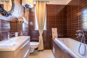 a bathroom with a tub and a toilet and a sink at Luxury Apartments with Private Pool and Sauna or with jacuzzi near Split , Sea View in Podstrana +31 photos
