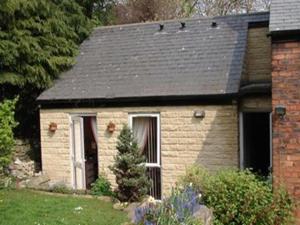 a small brick house with a black roof at Ellen House Bed and Breakfast in Matlock