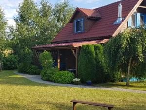 a house with a bench in front of it at LELE-LAKE super domek Mazury in Pasym