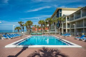 einen Pool mit Stühlen und ein Gebäude in der Unterkunft Bikini Beach Resort in Panama City Beach