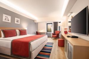 a hotel room with a bed and a flat screen tv at TRYP by Wyndham Ankara Oran in Ankara