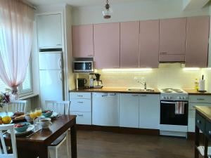 a kitchen with pink cabinets and a table with a tableablish at Tina's Place in Pori