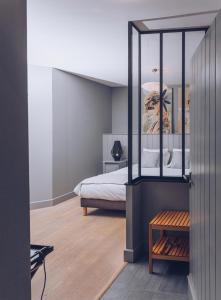 a bedroom with a bed and a wooden floor at Plumes & Coton in Écurie