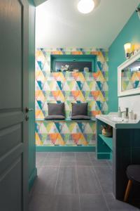baño con lavabo y pared de mosaico en Plumes & Coton en Écurie