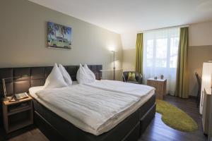 Postel nebo postele na pokoji v ubytování Herisau Swiss Quality Hotel