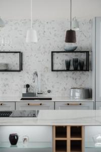 uma cozinha com armários brancos e um lavatório em Luxury Apartment Hovi em Naantali
