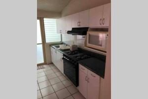 a kitchen with a microwave and a stove top oven at Increíble Suite Alberca Bernardo Quintana 12C in Mendiola