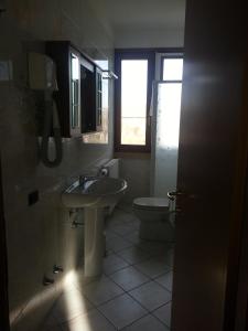 a bathroom with a sink and a toilet and a window at Agriturismo Corte Trincerone in Mantova