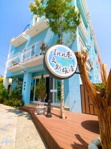 a sign in front of a blue building at Inn巷文創旅店 Inn siang B&B-墾丁夢幻島 in Sigou