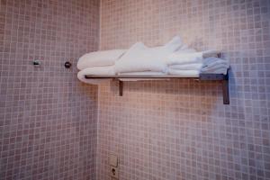 une pile de serviettes sur une étagère dans une salle de bains dans l'établissement Apartaments Ashome, à Canillo
