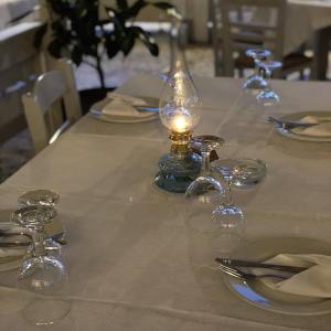 uma mesa com copos de vinho e uma vela em Mpiritis Mare em Cálcis