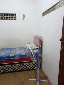 a small bed in a room with a fan at Homestay Mas Arjuna - Female Only in Bagongsabrangan +9 photos