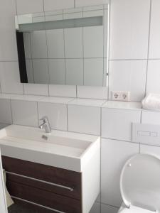 a white bathroom with a sink and a toilet at Gasthaus Römer in Haigerloch
