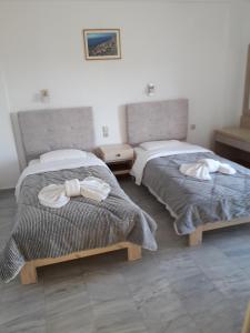 a bedroom with two beds with bows on them at Knossos Hotel in Kalamaki