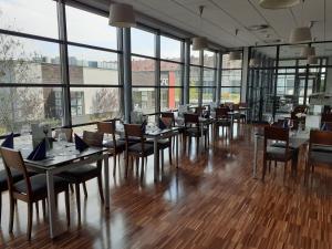 a dining room with tables and chairs and windows at Weiser Hotel in Wrocław