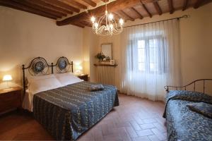 - une chambre avec un lit et une fenêtre ornée d'un lustre dans l'établissement Il Lebbio Agriresort, à Montaione