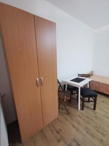 a cupboard in a room with a table and a bed at Apartmani Gmitrovic in Rtanj