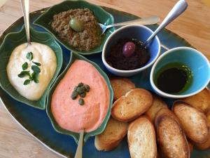 a plate of food with bread and dip and dips at Le Coteau d'Olliergues in Olliergues