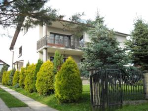 a house with a balcony and a row of trees at Wczasy od Maluszka do Staruszka in Ryglice