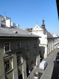 a city street with a white building and a white van at Apartment Świetego Tomasza in Krakow