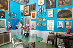 a room with a table and a wall of pictures at Anima B&B in Ceglie Messapica