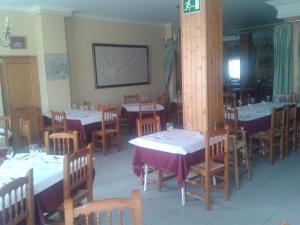 a dining room with tables and chairs and a screen at Hostal Restaurante Los Bronces in Riópar +22 photos