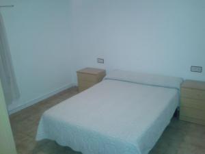 1 dormitorio pequeño con 1 cama y 2 mesitas de noche en Hostal Restaurante Los Bronces, en Riópar