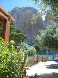 un jardín con una montaña en el fondo en CASE PUNTA MONACO - Appartamenti con wi-fi e parcheggio privato gratuito, en San Vito lo Capo