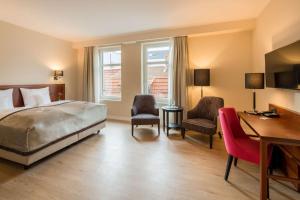 a bedroom with a bed and a desk and chairs at Best Western Plus Hotel Excelsior in Erfurt