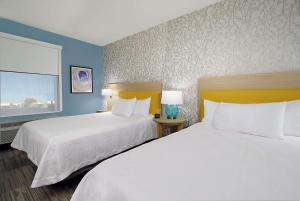 a hotel room with two beds and a window at Days Inn by Wyndham Beaumont West I-10 Walden in Beaumont