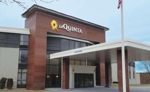 a building with a sun sign on the side of it at La Quinta by Wyndham Boston-Andover in Andover