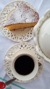 un trozo de pastel en un plato junto a una taza de café en B&B Tre Confini, en Giaveno