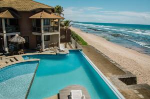 un complejo con piscina junto a la playa en Pousada Restinga Apart Service- Aeroporto en Lauro de Freitas