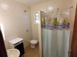 La salle de bains est pourvue d'un rideau de douche avec des monstres. dans l'établissement Tranquilidade a alguns passos da praia - churrasqueira, super wi-fi!, à Matinhos