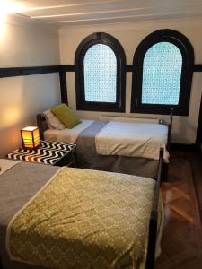 two beds in a room with two windows at Casa Ryan in Santiago