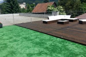 a patio with green grass on a deck at Apartment Unimix in Liptovský Mikuláš