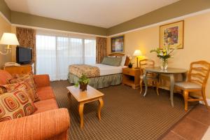 Habitación de hotel con cama y sala de estar. en Legacy Vacation Resorts - Reno, en Reno
