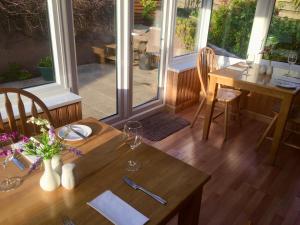 a dining room with a table and chairs and windows at White Cottage B&B in North Kessock