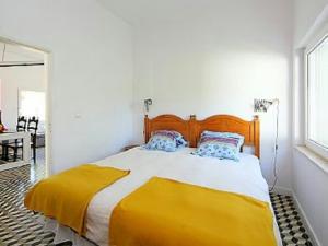 een slaapkamer met een groot bed met een gele deken bij Casa da Guarda in Alvor +20 foto's