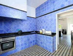 een blauwe betegelde keuken met een wastafel en een fornuis bij Casa da Guarda in Alvor