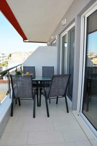 a patio with a table and chairs on a balcony at Princess Luxury Suite in Paralia Katerinis