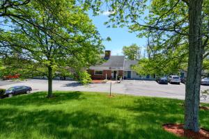 a yard with trees in front of a building at Knight's Inn Boston/Danvers in Danvers