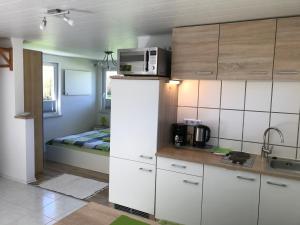 a kitchen with white cabinets and a bed in a room at Ferienbungalow Grünbach in Grünbach
